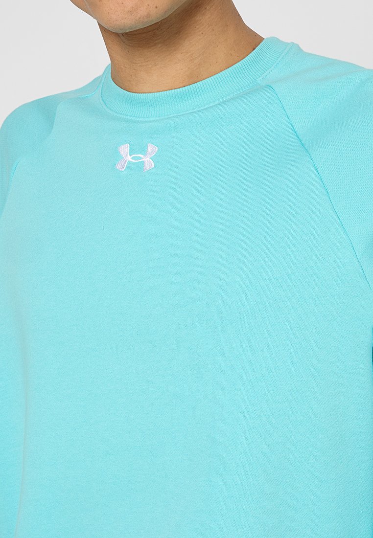 Sudadera en un suave tono verde azulado con cuello redondo y mangas raglán, que presenta un pequeño logo blanco en el pecho. Tejido ligero y suave.