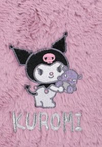 Lilla fluffy baggrund med en broderet karakter i et sort outfit, der holder en lilla plysbamse. Teksten "KUROMI" er syet nedenunder.
