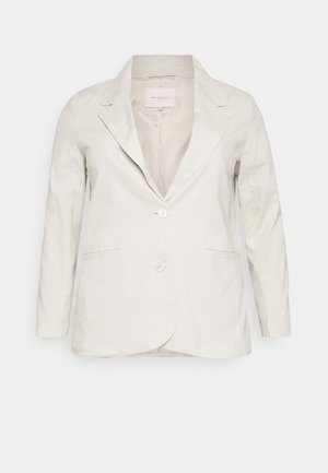 Blazer blanc pour femme sur mesure, manches longues, deux boutons devant et col à revers encoche sur fond uni.