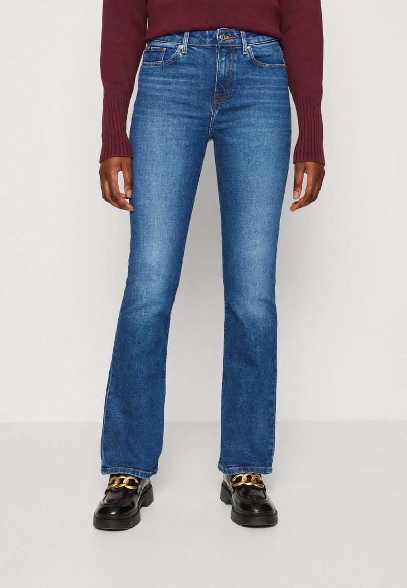 Blå denimflared jeans med medelhög midja, med en klassisk femfickdesign och subtila sömnadsdetaljer.