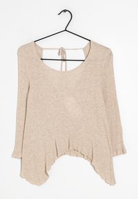 Beige geripptes Langarmshirt mit weitem Ausschnitt, offenem Rücken und Bändern. Hat einen abgerundeten Saum mit längerem Rücken und einem strukturierten Stoff.