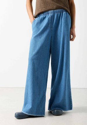 Light blue wide-leg denim pants with an elastic waistband and side pockets, featuring a frayed hem and a textured finish.