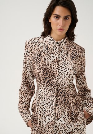 Leopard print blouse in lightweight fabric, featuring a collared neckline, long sleeves, and button closure. Earthy tones dominate the pattern.