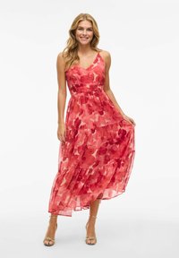 Robe maxi avec un motif floral dans des nuances de rouge et de rose, avec un col en V, des bretelles réglables et un design de jupe à niveaux.