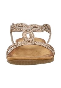 Dames sandaal met een platte uitstraling, voorzien van een gouden metalen band versierd met strass en een gevoerde, tan leren voetbed.