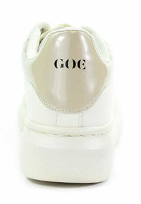 Białe sneakersy o gładkim skórzanym wykończeniu, z błyszczącym beżowym zapiętkiem i czarnym napisem "GOE". Gruba podeszwa zwiększająca wysokość.