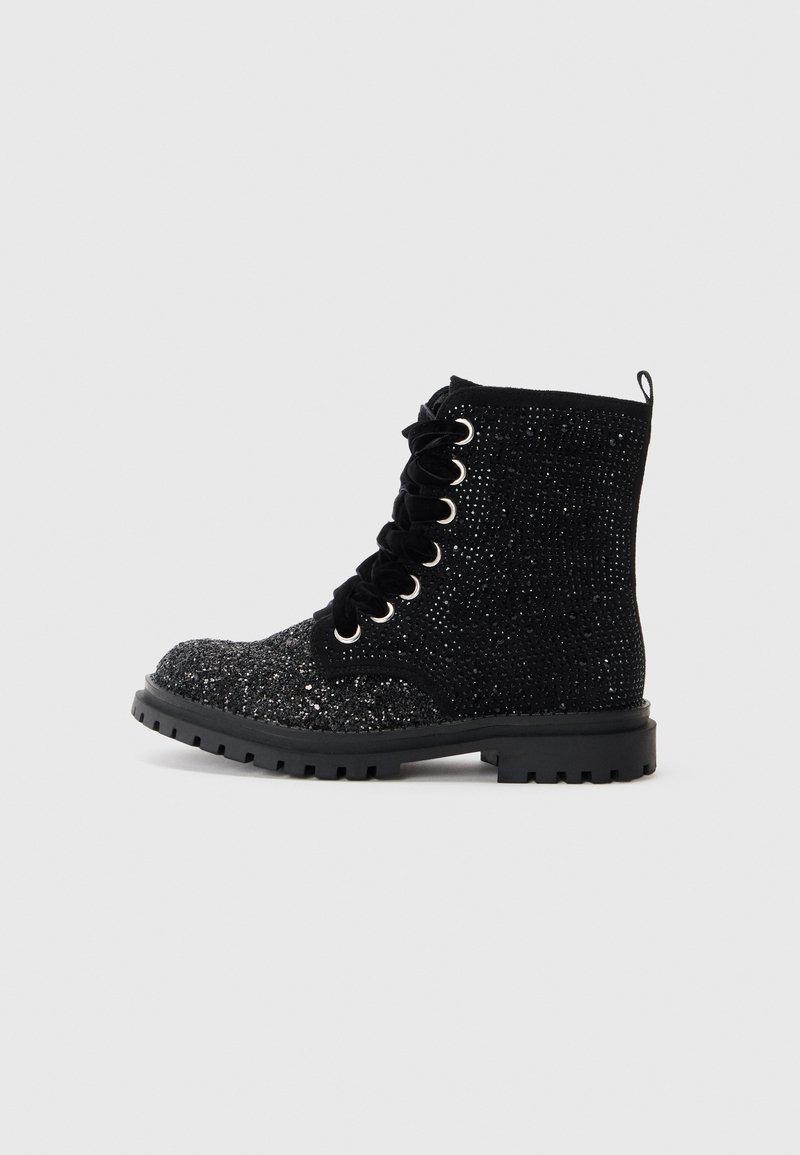 Botas negras con cordones, con parte superior brillante, superficie texturizada, puntera redonda, ojetes metálicos y suela de goma negra con patrón de relieve.