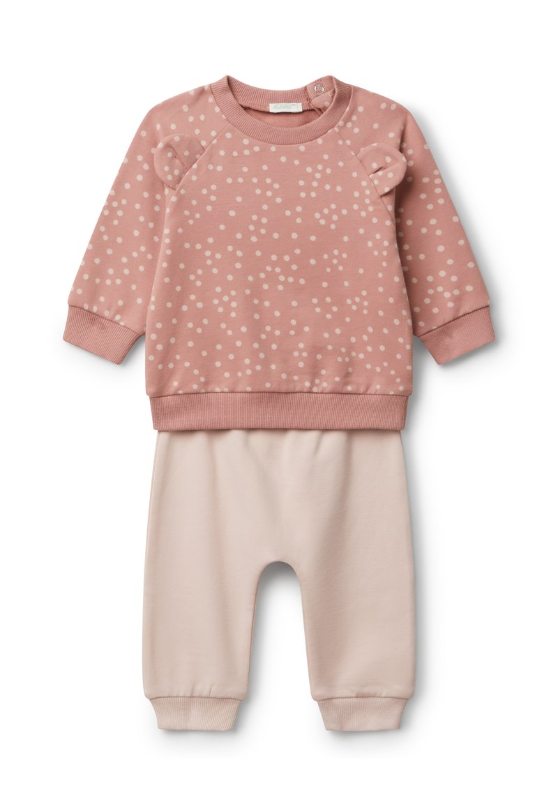 Dwuczęściowy zestaw dla niemowląt składający się z różowej bluzy w kropki z małymi uszkami na ramionach oraz jednolitych jasnoróżowych spodni z mankietami.