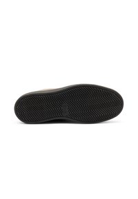 Suela de zapato de goma negra con un patrón de espiga, que presenta un borde redondeado y una superficie plana y texturizada. Marca grabada en el centro.