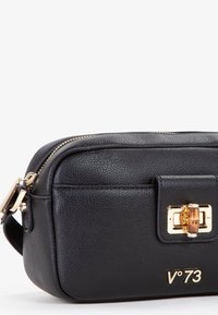 Borsa a tracolla in pelle nera con superficie texturizzata, accessori in oro e un dettaglio di chiusura unico. Presenta una forma piatta e una tracolla regolabile.
