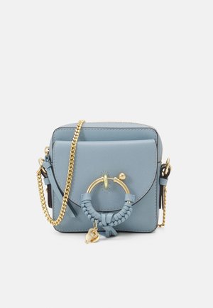 Sac bandoulière en cuir bleu clair avec rabat avant, bandoulière en chaîne dorée et anneau décoratif doré avec détail en cuir tressé.