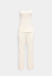 Ensemble de pyjama en maille côtelée couleur crème avec un haut à bretelles fines et un pantalon droit, orné de légers pois roses.