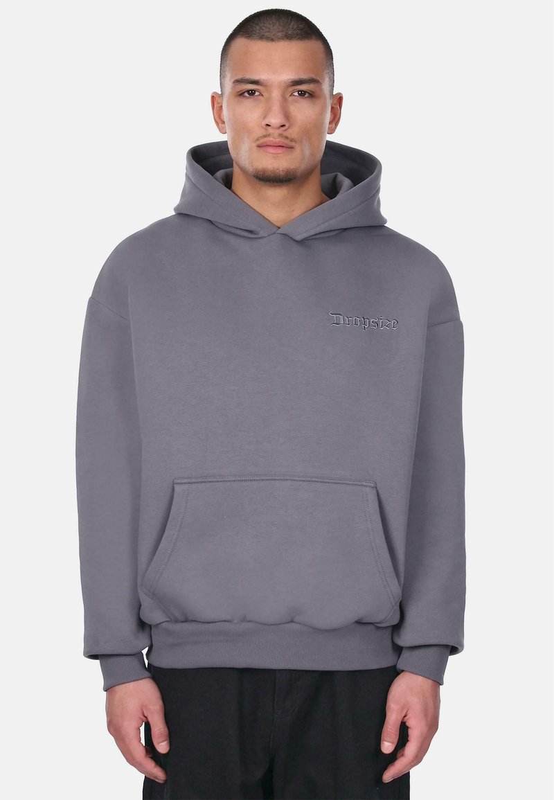 Grijze hoodie met een kangoeroezak, ribbelmanchetten en een klein geborduurd logo op de borst. Gemaakt van zachte, textuurstof.