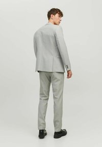Light gray suit jacket and matching trousers, smooth texture, slim fit design, with subtle check pattern, finished with button accents.