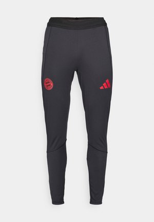 Black athletic pants made of stretchy fabric. Features red Bayern Munich logo and three stripes logo on the side. Elastic waistband for comfort.