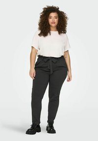 Lightweight white blouse with short sleeves is paired with dark grey, high-waisted pants featuring a tied belt. Black chunky-heeled shoes complete the outfit.