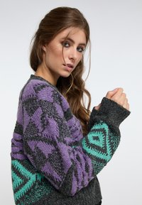 Maglione a maglia con motivi geometrici in viola, grigio e verde acqua; tessuto testurizzato con maniche lunghe e polsini a coste.