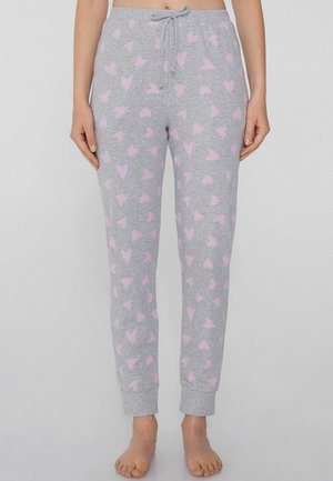 Grijze pyjamabroek met een trekkoord in de taille, voorzien van een verspreid patroon van roze harten. De gekuifte enkels zorgen voor een aansluitende pasvorm. Zachte, casual stof.