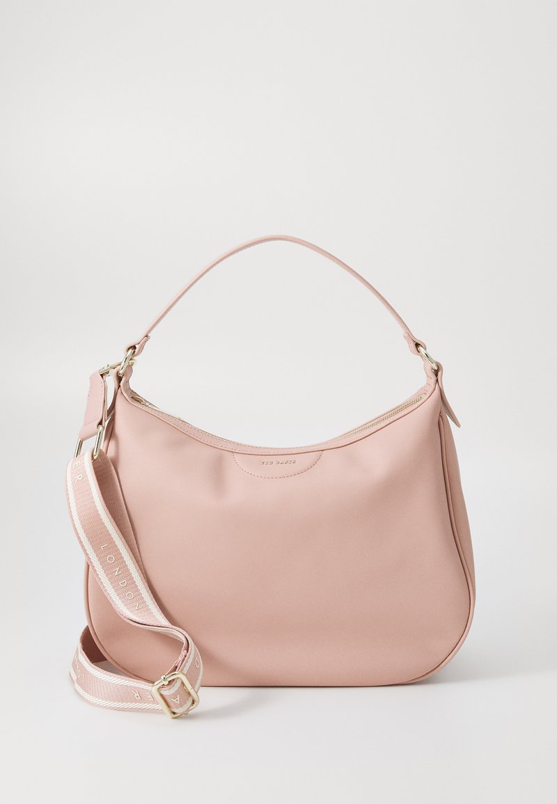 Sac à épaule en cuir rose avec une silhouette courbée. Doté d'une fermeture éclair dorée et d'une bandoulière en tissu amovible avec un logo. Texture lisse.