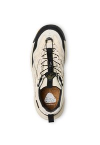 Scarpa atletica beige e nera con tomaia texturizzata, sistema di allacciatura nero e soletta in sughero. Presenta un'etichetta con il logo sopra la punta.