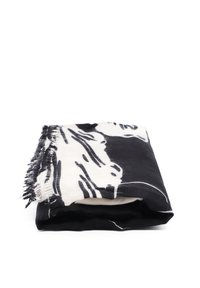 Sciarpa a righe e forme in bianco e nero con bordi frangiati, piegata ordinatamente per l'esposizione. Tessuto morbido e texture.