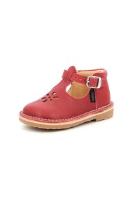 Zapato para niño pequeño de cuero rojo con diseño de flor recortada, correa ajustable con hebilla plateada y suela de goma beige. Textura suave.