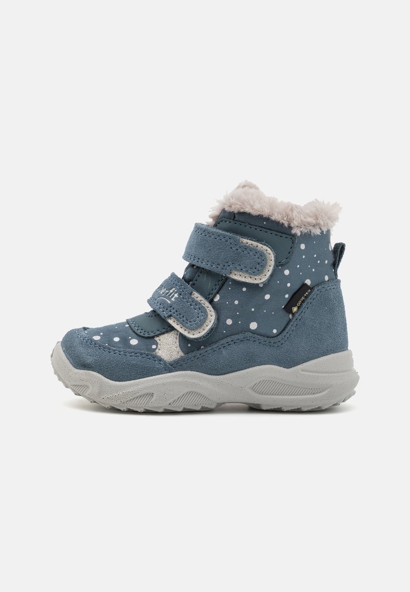 Botte d'hiver pour tout-petit de couleur bleue avec des pois blancs, deux bandes auto-agrippantes, doublure en fausse fourrure, semelle grise, et étiquette imperméable Gore-Tex.