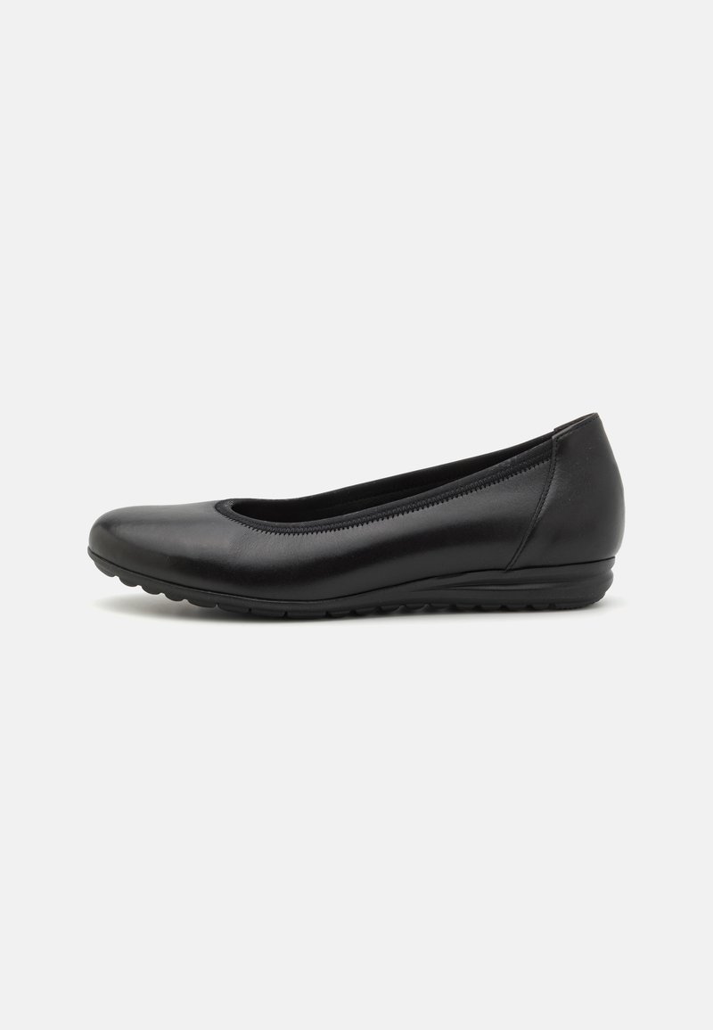 Chaussure ballerine femme en cuir noir avec un petit talon compensé et un bout arrondi, vue de côté sur un fond clair.