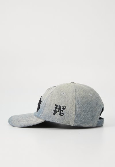 Casquette en denim avec une visière incurvée et sangle réglable. Présente des accents brodés noirs sur les côtés gauche et droit à l'avant. Couleur bleu clair.