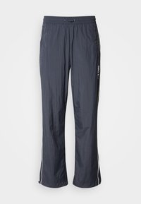 Marineblauwe lichte trainingsbroek met een elastische tailleband, zijzakken en witte accentstrepen aan de zijkanten. Glad textuur.