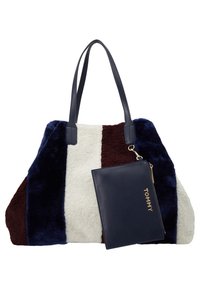 Sac fourre-tout avec des rayures verticales bleu marine, blanc et marron à texture douce et petite pochette bleu marine attachée avec fermeture éclair dorée et texte "TOMMY".