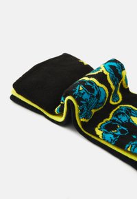 Black socks featuring a vibrant blue and yellow bear pattern, with a soft knit texture and contrasting color edges.