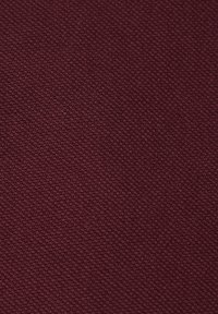 Bordowy materiał o teksturowanej powierzchni z delikatnym, tkanym wzorem; gładkie wykończenie; średnia waga odpowiednia do różnych zastosowań.