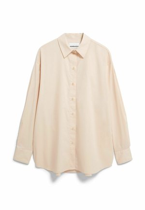 Chemise beige clair à manches longues avec col classique, boutons sur le devant et épaules légèrement tombantes, confectionnée dans un tissu doux et lisse.