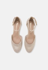 Zapato slingback de ante beige con punta redonda, cinta en el tobillo y hebilla en tono dorado. El interior es suave con una plantilla neutral. Talla 37.