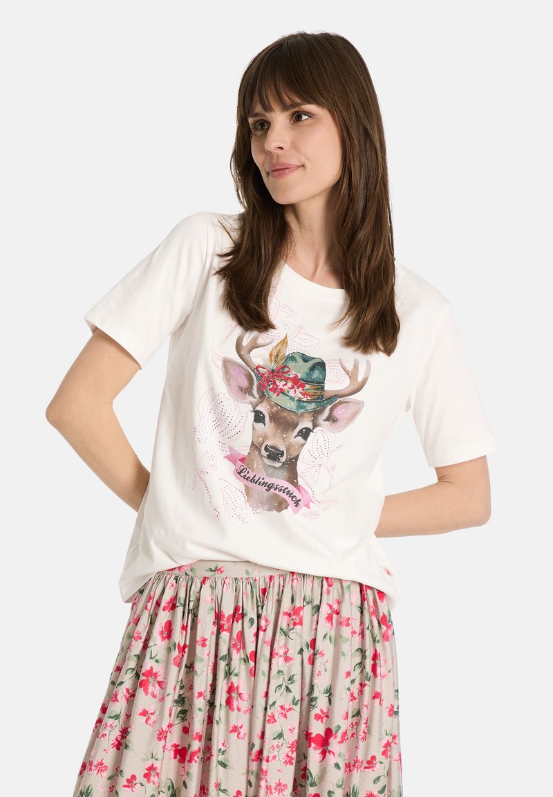Weißes T-Shirt mit kurzen Ärmeln, das eine Hirschillustration zeigt, der einen blumigen Hut trägt. Kombiniert mit einem Rock im floralen Muster in sanften Farben.