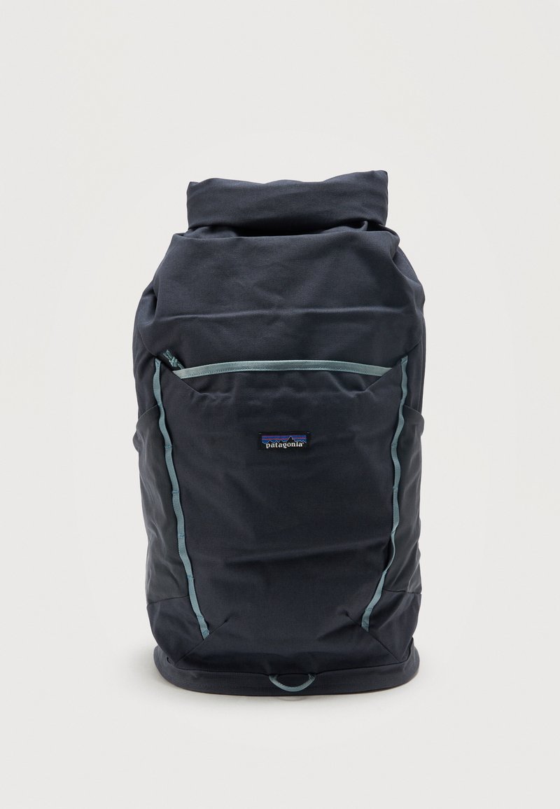 Μαύρο σακίδιο πλάτης Patagonia με ρολό στο πάνω μέρος, μπροστινή τσέπη και ανοιχτό μπλε τελείωμα πάνω σε απλό λευκό φόντο.