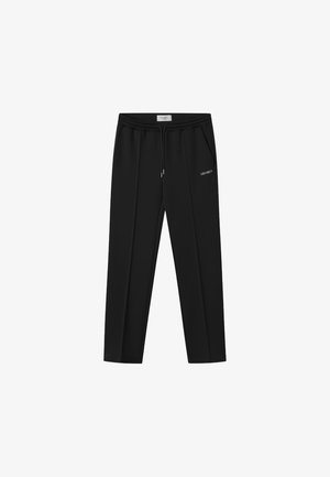 Zwarte joggingbroek gemaakt van zachte stof, met een tailleband met trekkoord, twee zijzakken en een klein wit logo op de linkerdij.