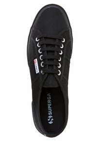 Svart canvas sneakers med en strukturerad yta, rund tå och vita snörningar. Har silverfärgade öglor och en "SUPERGA"-logotyp på innersulan.