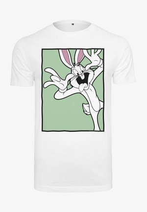 Camiseta blanca de algodón con un conejo de dibujos animados de orejas rosas, rostro expresivo y manos, dentro de un marco cuadrado verde en el frente.