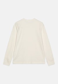 Long-sleeve T-shirt in cream cotton with a ribbed texture. Features a crew neckline and straight hem, with simple, clean stitching.