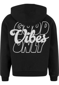 Felpa nera con cappuccio regolabile, con la scritta "GOOD VIBES ONLY" in grande testo bianco sul retro. Tessuto morbido e vestibilità comoda.