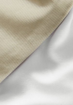 Zwei überlappende Stoffmuster: eines beige mit einer strukturierten, gerippten Oberfläche und eines glatt, weiß, beide zeigen sanfte Falten.