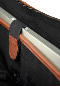 Schwarze Laptop-Hülle aus Stoff mit einem braunen Lederakzent und einem Sicherungsriemen. Verfügt über einen Reißverschluss und ein weiches Innenfutter.