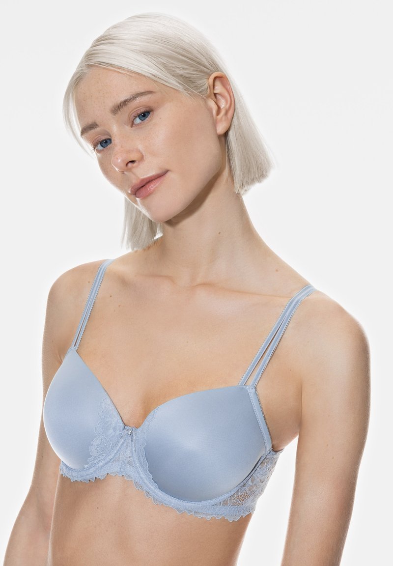 Vaaleansininen pitsi-rintaliivi, jossa on sileät kupit, säädettävät olkaimet ja hennon pitsireunus pohjassa. Pehmeä rakenne, jossa on hieno kiilto.