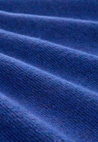 Blauwe textuurstof met opvallende ribbel lijnen. Het materiaal lijkt zacht, met een licht fuzzy afwerking en een gelijkmatige kleurdistrubutie.