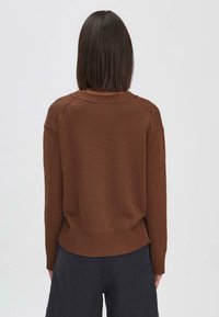 Brauner Strickpullover mit Rundhalsausschnitt, gerippten Bündchen und Saum, in lockerer Passform und mit strukturierter Oberfläche. Rückansicht angezeigt.