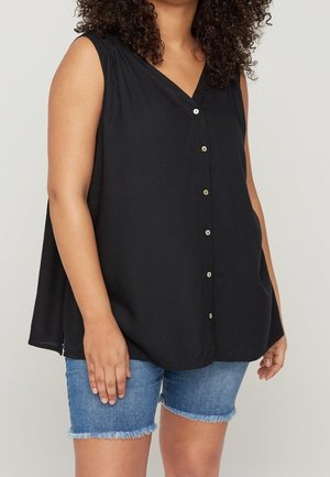 Blouse sans manches noire avec un col en V, ornée de boutons sur le devant, coupe décontractée et tissu texturé. Assortie avec un short en denim.