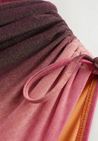 Meerkleurige stof met een verloop van donkerpaars naar roze. Heeft een gathered ontwerp met een elastische trekkoord en een contrasterende oranje naad.