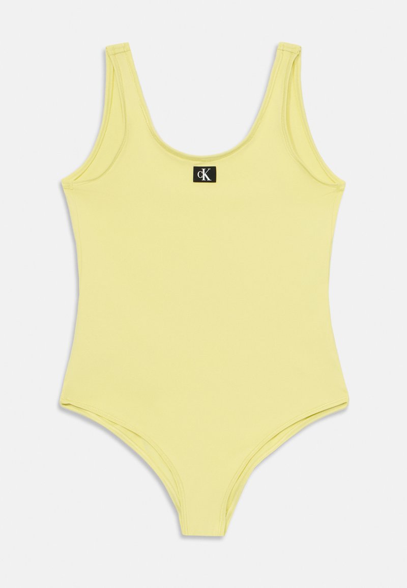 Sárga egyrészes fürdőruha kerek kivágással és széles pántokkal. Az elején cK logó címke található. Simogatós, rugalmas anyag.